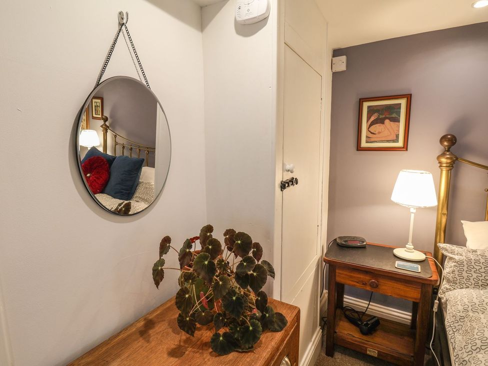 A bedroom with a mirror and a lamp at Apartment at Mulgrave House Saltburn-by-the-Sea