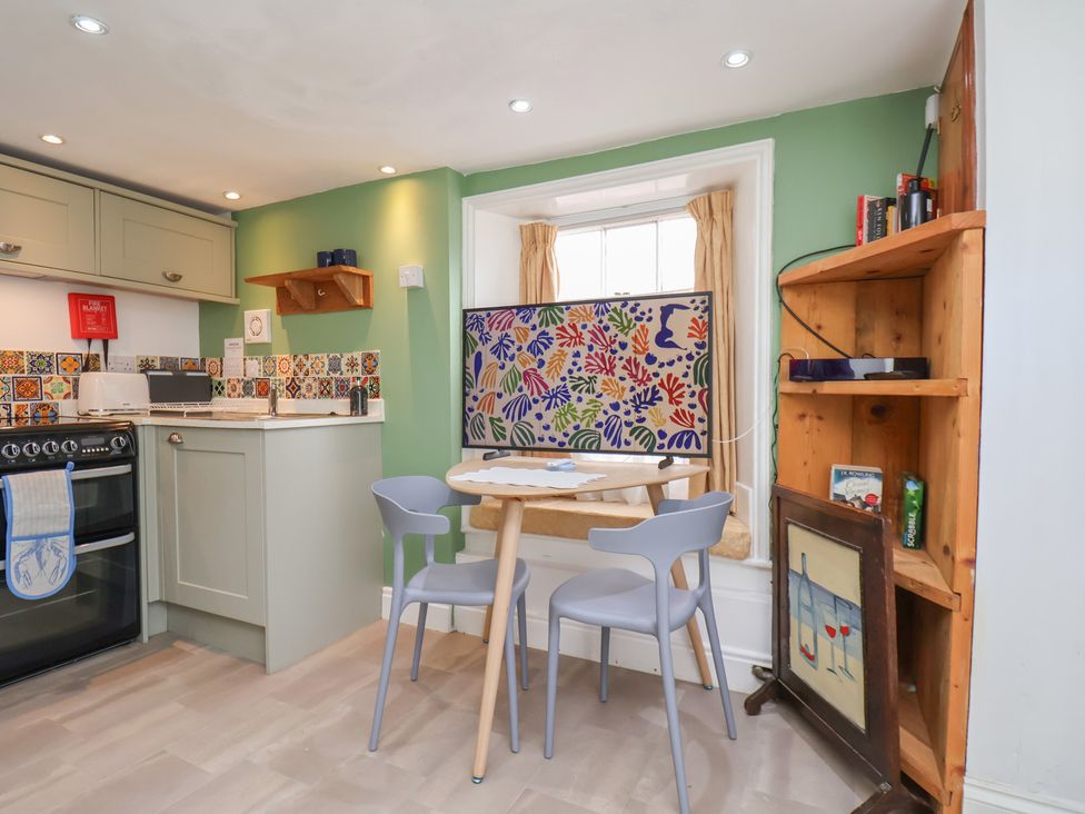 A kitchen with stove and dining table at Apartment at Mulgrave House Hinderwell near Staithes