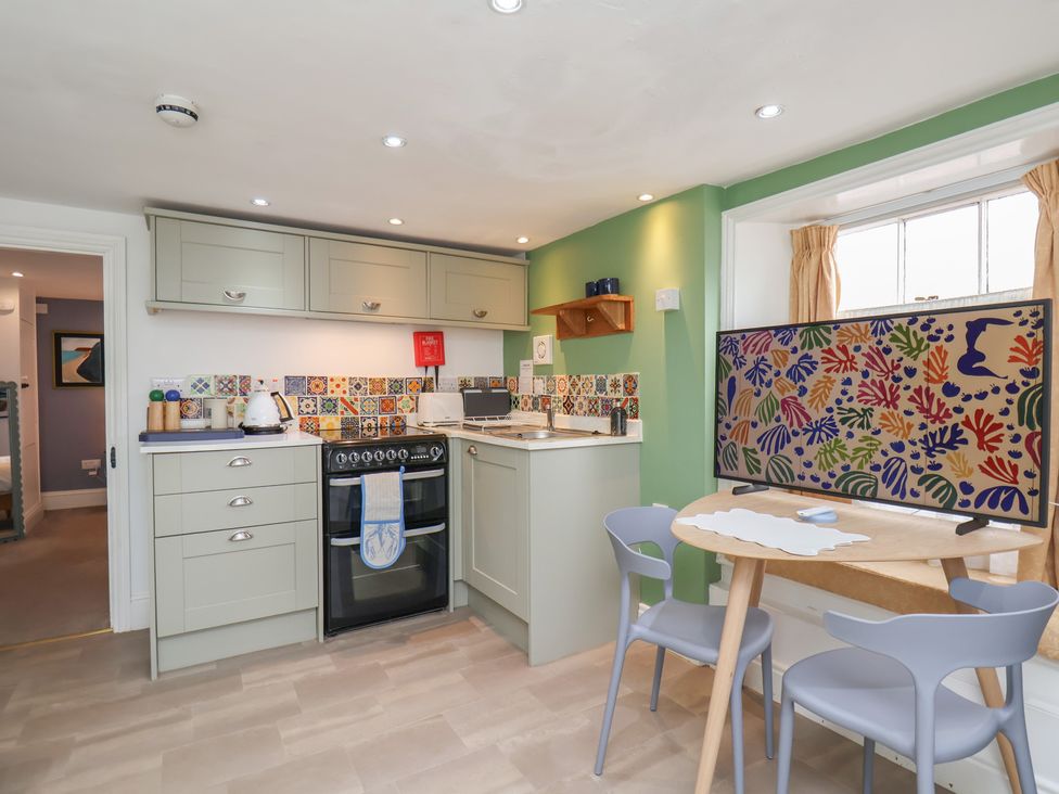 A kitchen with cabinets and a dining table at Apartment at Mulgrave House Hinderwell near Staithes