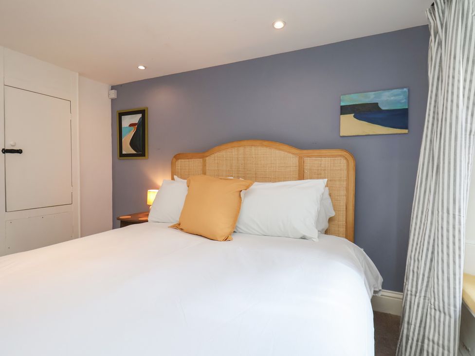 A bedroom with a bed and paintings on the wall at Apartment at Mulgrave House Hinderwell near Staithes