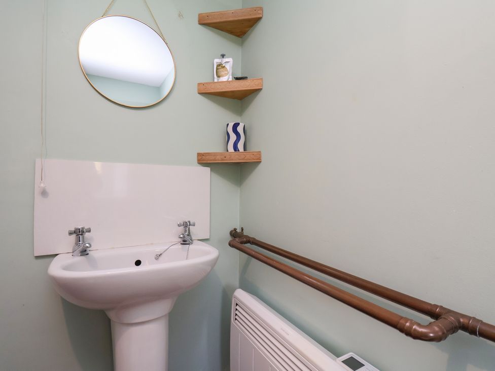 A bathroom with a sink and shelves at Apartment at Mulgrave House Hinderwell near Staithes
