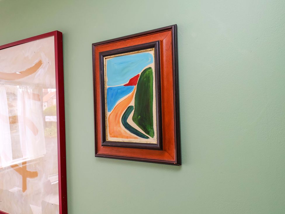 A framed painting on a green wall at Apartment at Mulgrave House Hinderwell near Staithes