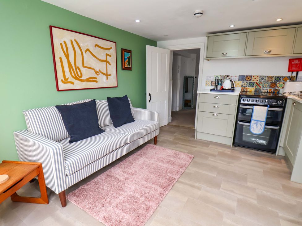 A living room with a sofa and kitchen area at Apartment at Mulgrave House Hinderwell near Staithes