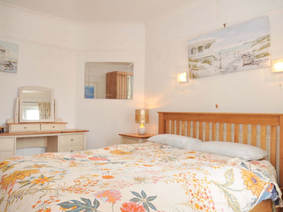 A bedroom with a bed and dresser at Porthmeor Wadebridge