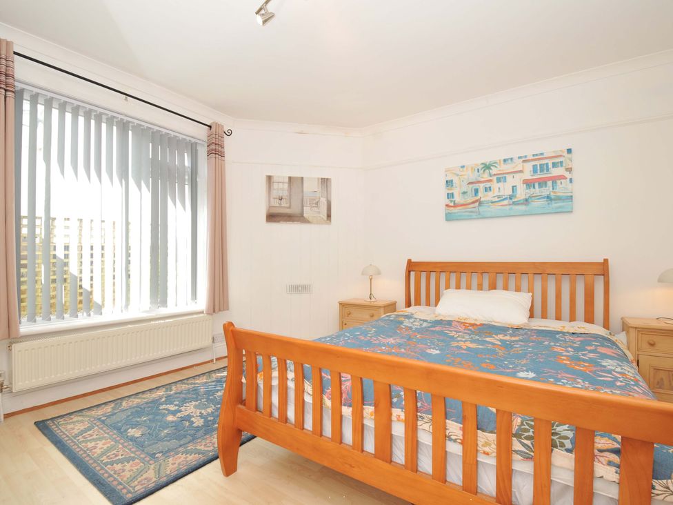 A bedroom with a wooden bed and nightstands at Porthmeor in Wadebridge