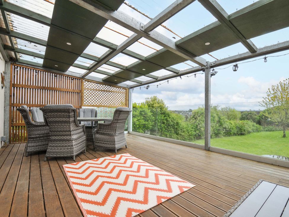 An outdoor area with seating and a table at Porthmeor in Wadebridge