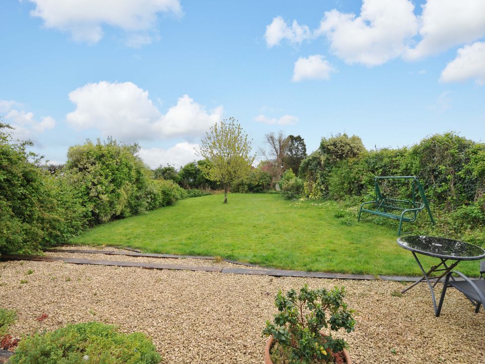 A garden with a tree and gravel at Porthmeor in Wadebridge