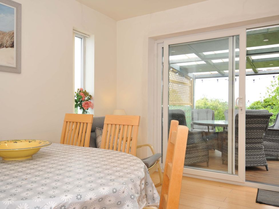 A dining room with a table and chairs at Porthmeor in Wadebridge