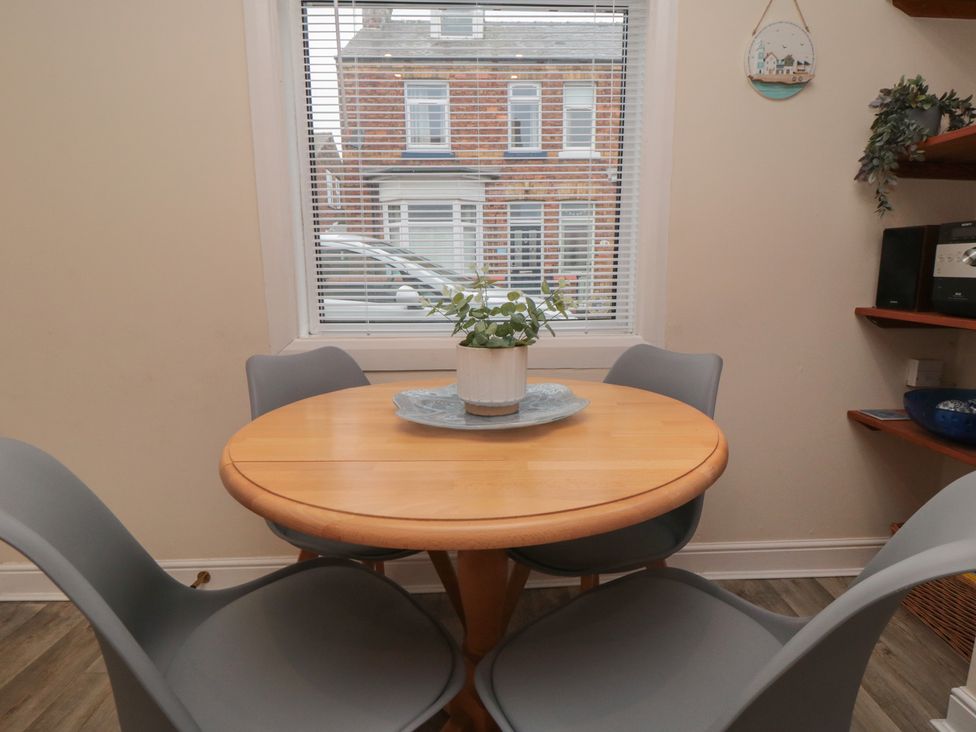 A dining room with a round table and potted plant at Seabreeze in Filey