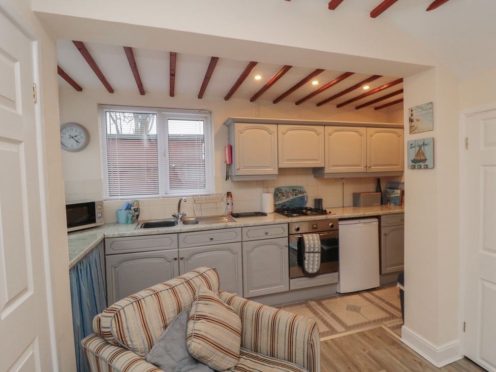 A kitchen with appliances and a couch at Seabreeze in Filey