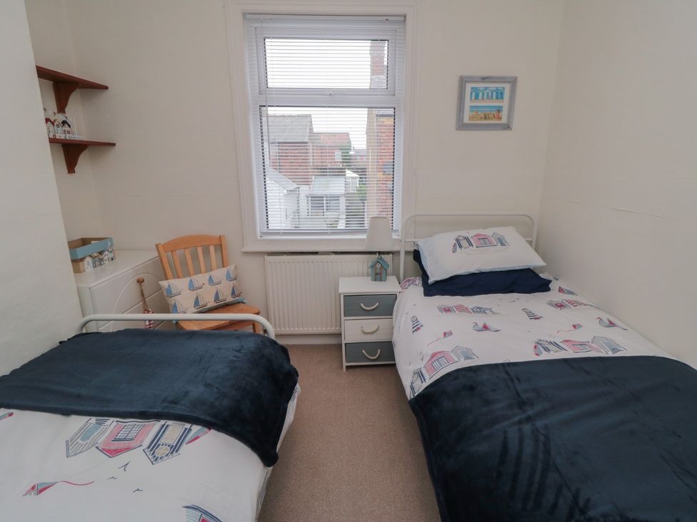 A bedroom with two beds and a chair at Seabreeze in Filey