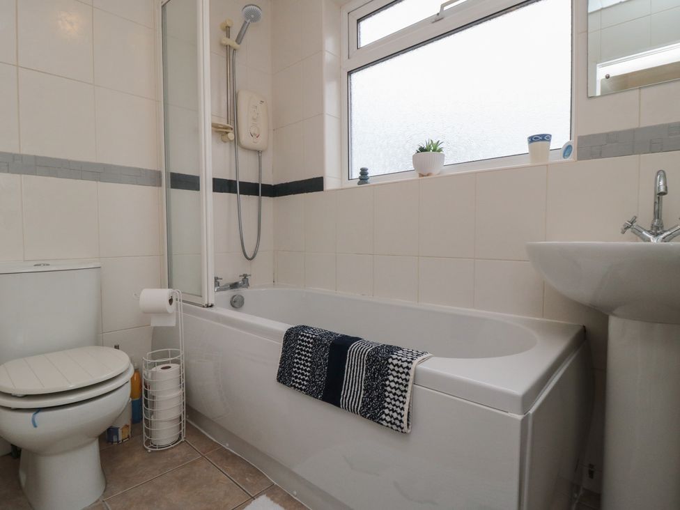 A bathroom with a bathtub, toilet, sink, and shower at Seabreeze in Filey