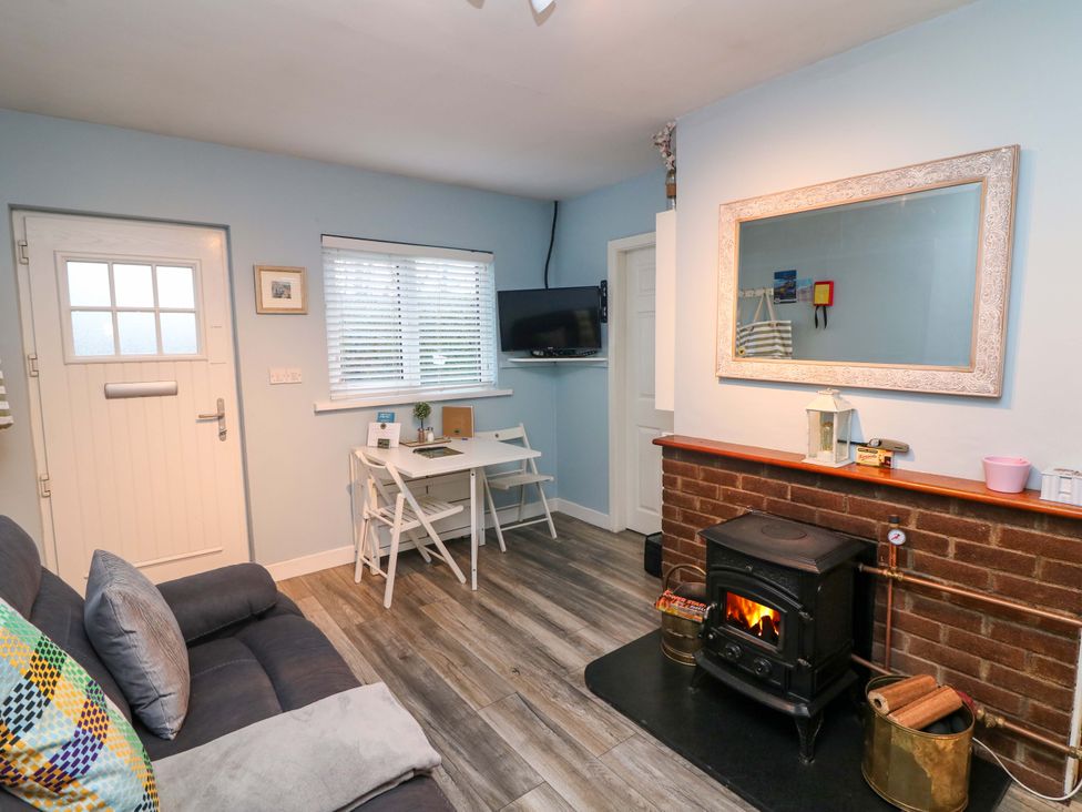 A living room with a sofa and dining table at Long Jack's in Ballygarrett, County Wexford