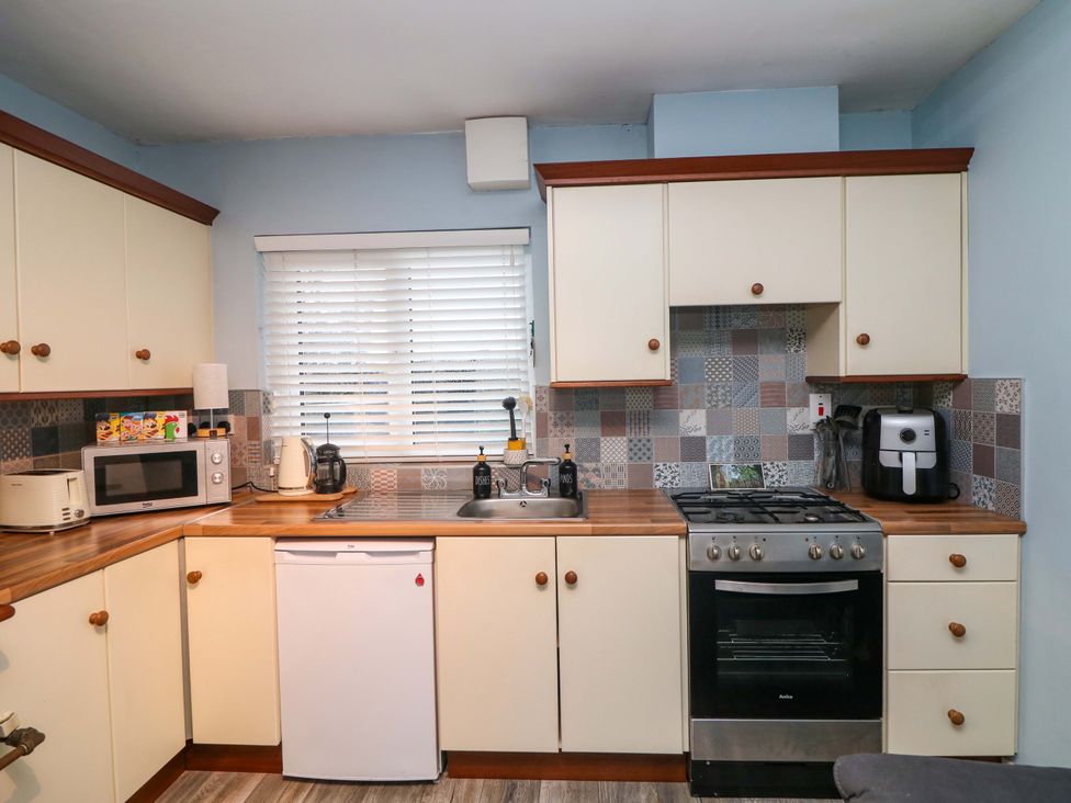 A kitchen with cabinets, appliances, and a sink at Long Jack's Ballygarrett, County Wexford