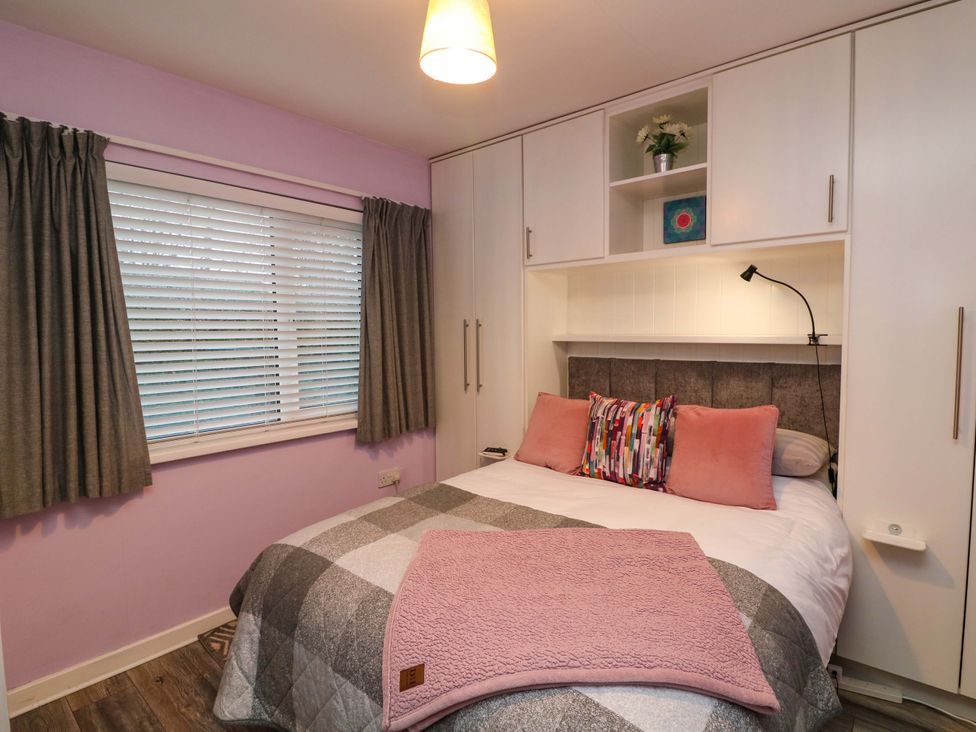 A bedroom with a bed and storage at Long Jack's, Ballygarrett, County Wexford