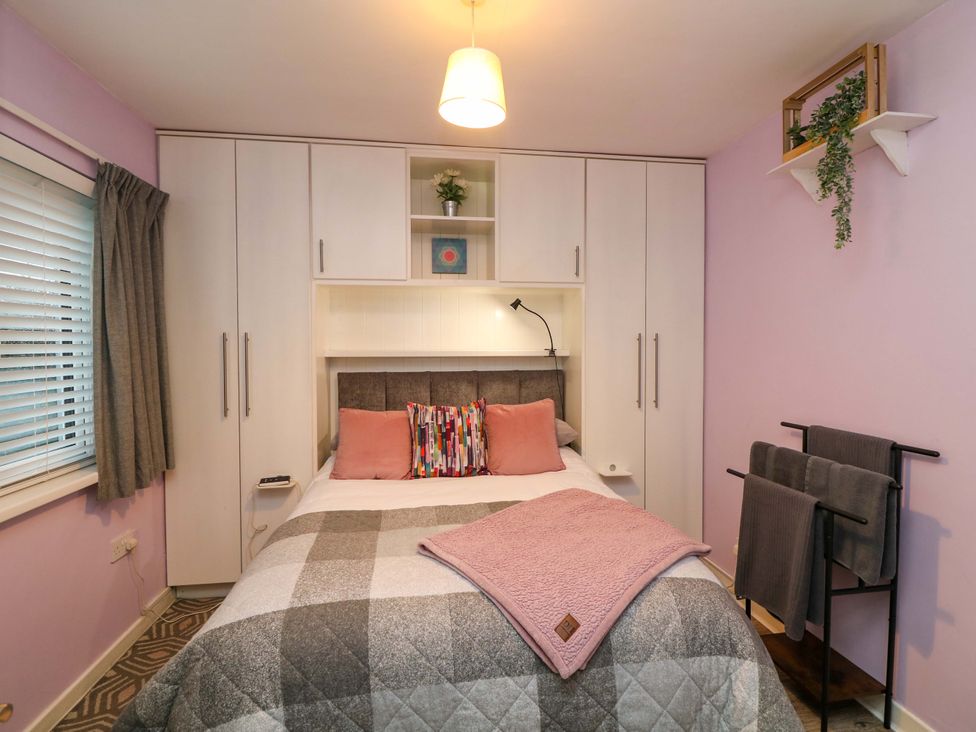 A bedroom with a bed and wardrobe at Long Jack's in Ballygarrett, County Wexford