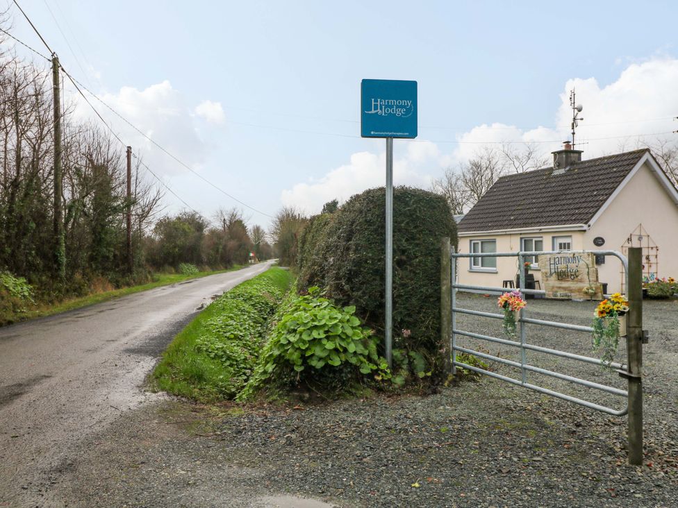 A roadside view of Harmony Lodge with a house and gate in Ballygarrett, County Wexford