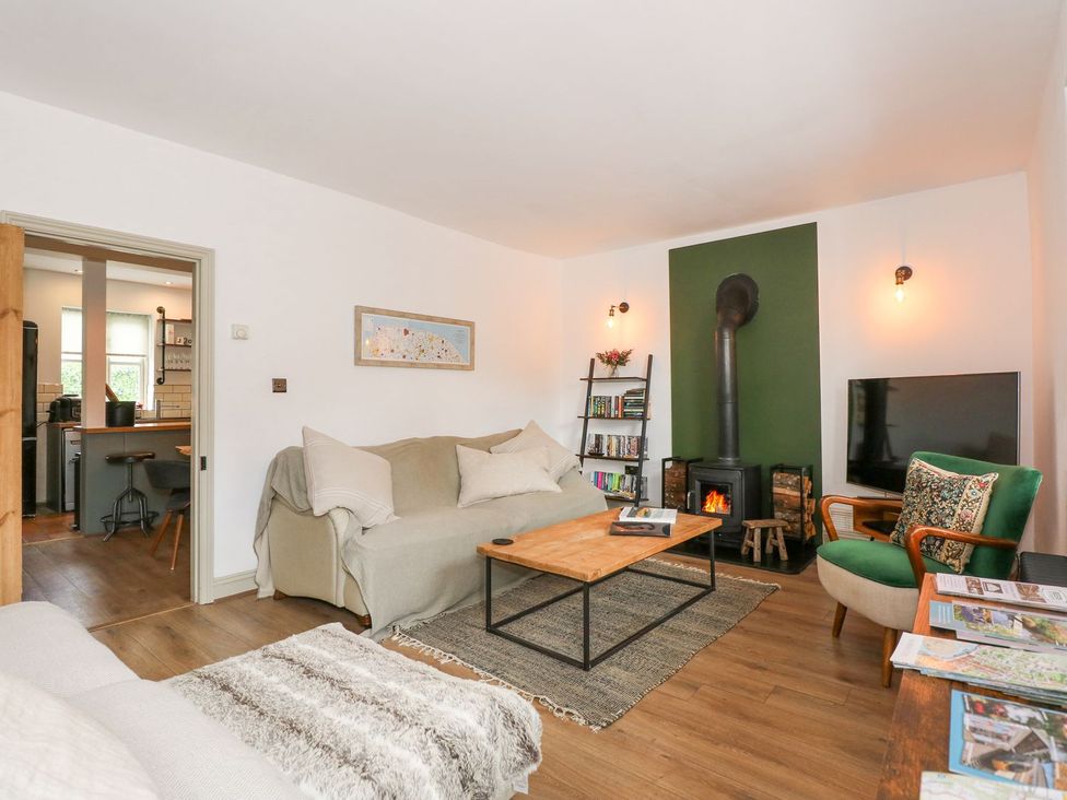 A living room with a sofa, coffee table, and fireplace at Joy's Cottage in Snettisham