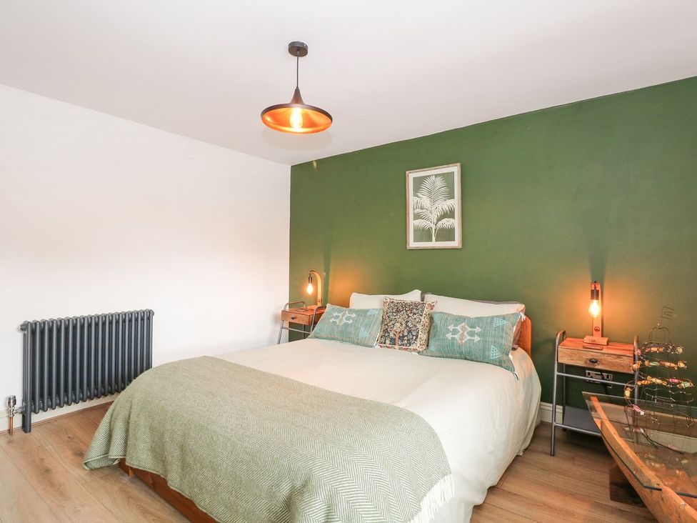 A bedroom with a bed and lamps at Joy's Cottage in Snettisham