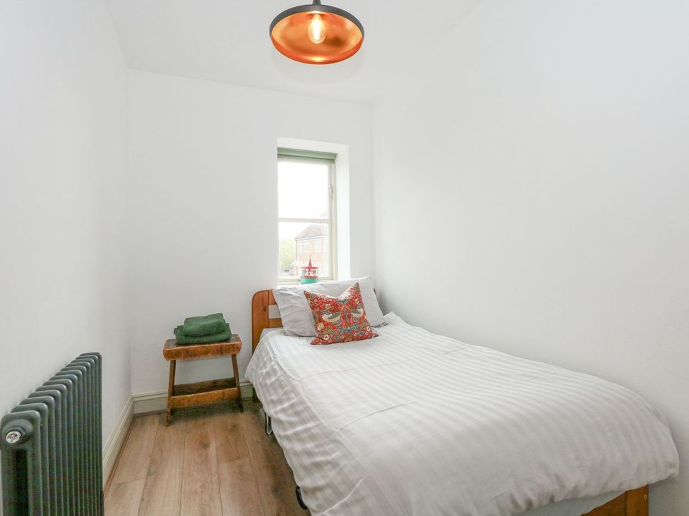 A bedroom with a bed and a window at Joy's Cottage Snettisham