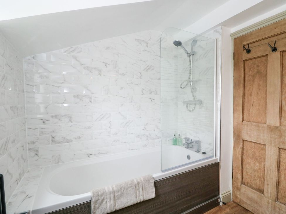 A bathroom with a shower and bath tub at Joy's Cottage in Snettisham