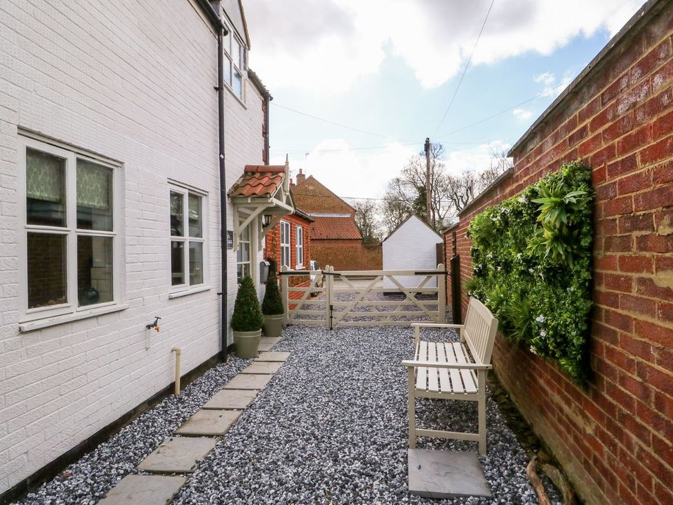 A garden with gravels and a bench at Joy's Cottage in Snettisham