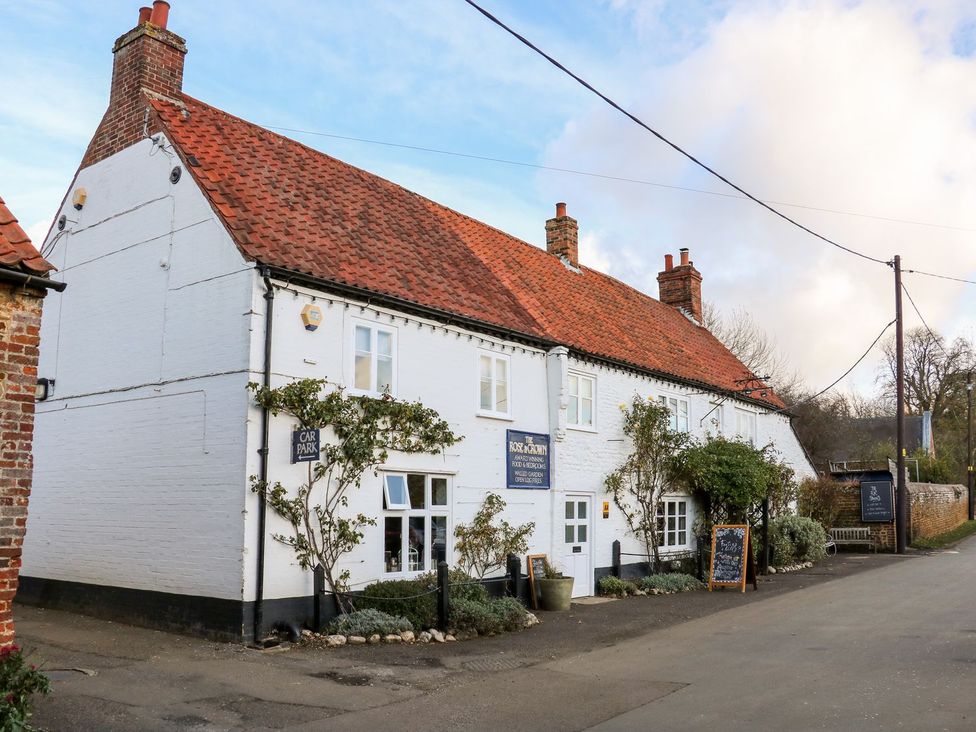 A building with a sign and car park at Joy's Cottage in Snettisham