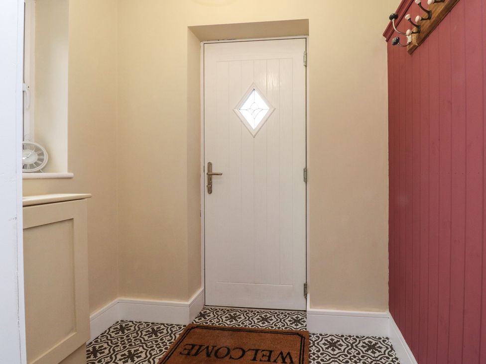 A hallway with a door and welcome mat at Wardenlea Preston