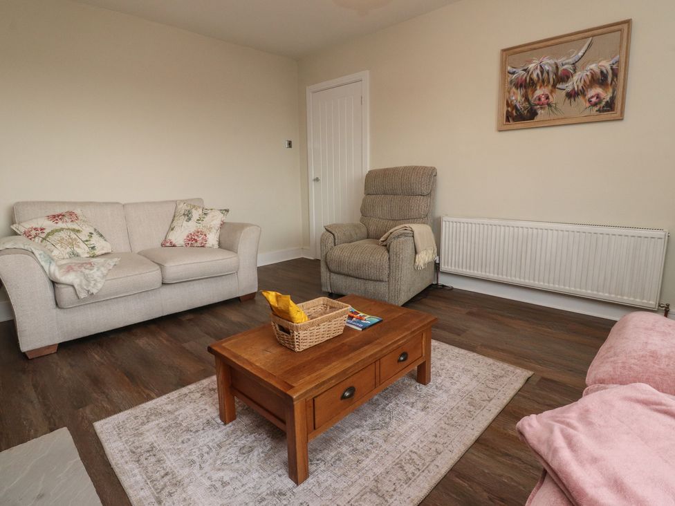 A living room with a sofa, armchair, and coffee table at Wardenlea in Preston