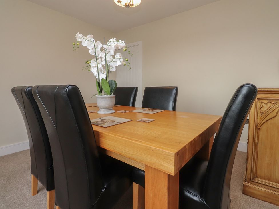 A dining room with a wooden table and black chairs at Wardenlea in Preston