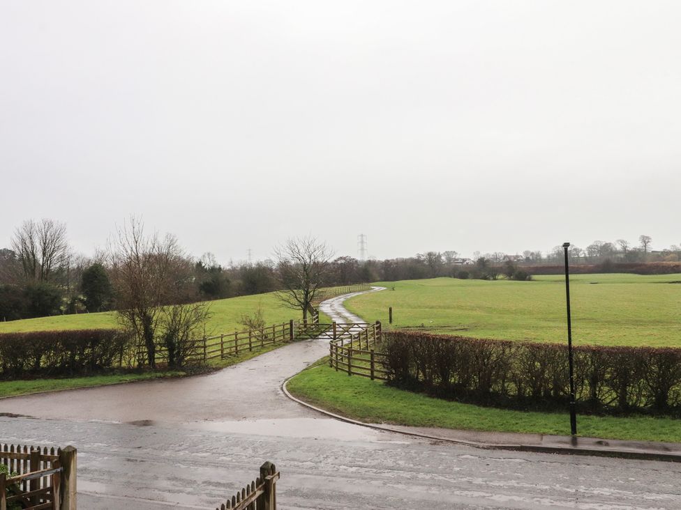 A field with a winding road and fence at Wardenlea Preston