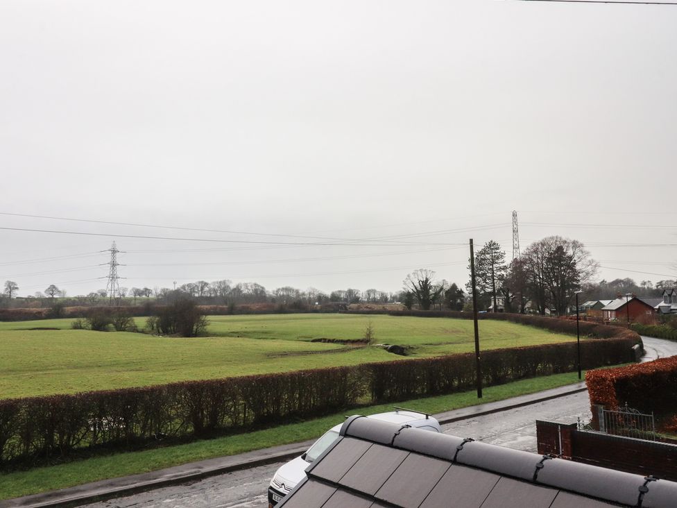A field with trees and power lines near a road at Wardenlea Preston