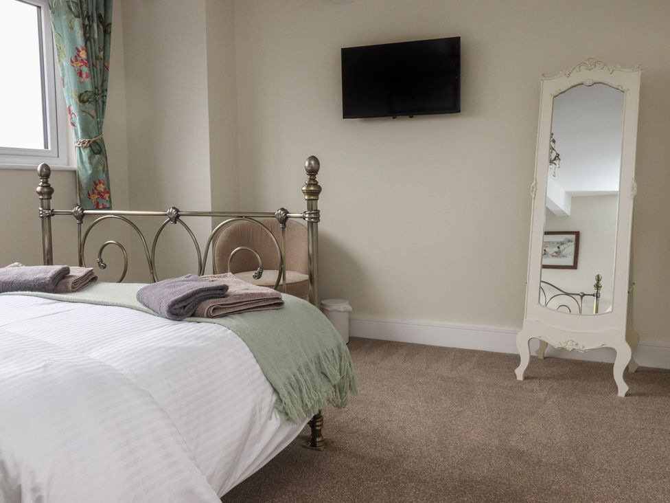 A bedroom with a bed, television, and a mirror at Wardenlea in Preston