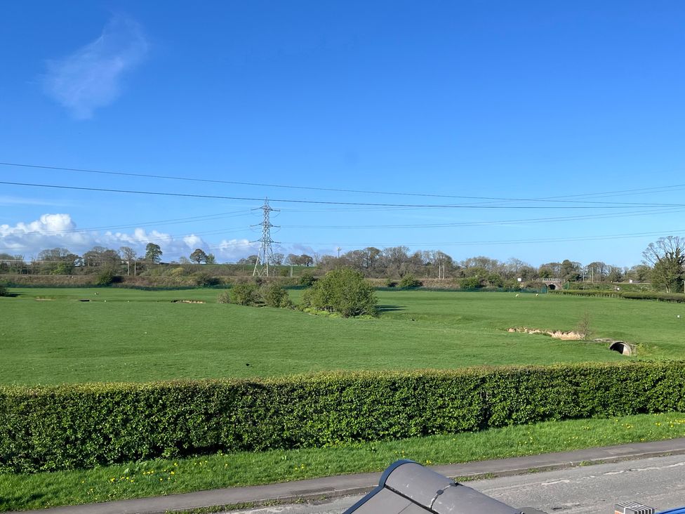 A green field with hedges and trees in Scorton at Wardenlea