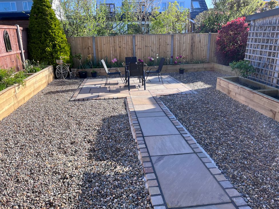 A garden with gravel pathways and seating area at Wardenlea in Scorton
