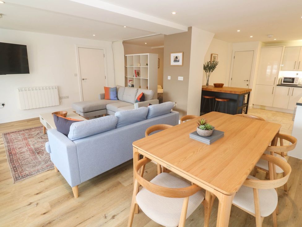 A living room with a sofa and dining table at 11 Fountain Court in Falmouth