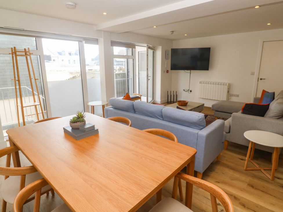 A living room with a dining table and sofa at 11 Fountain Court in Falmouth