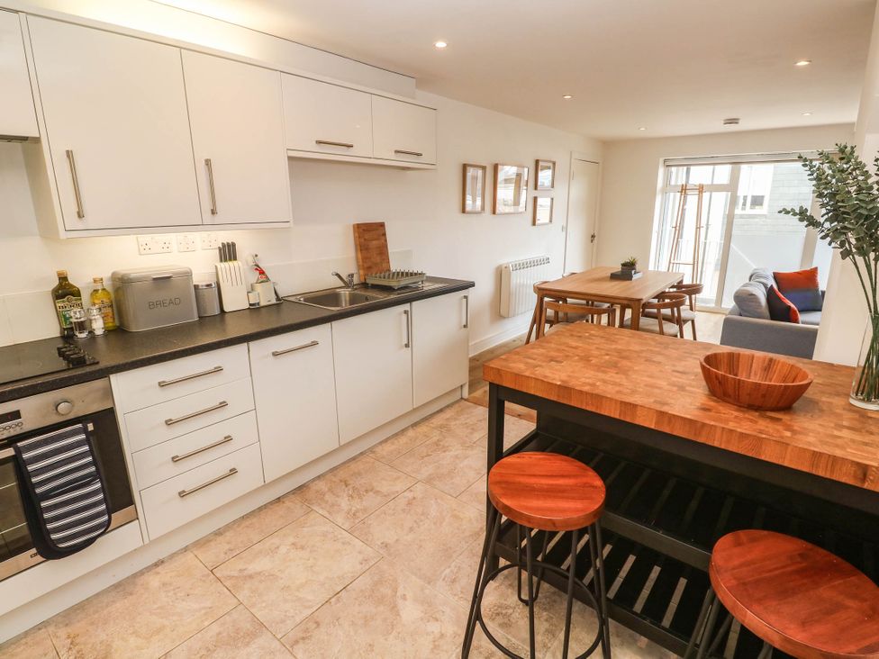 A kitchen with cabinets and dining area at 11 Fountain Court in Falmouth