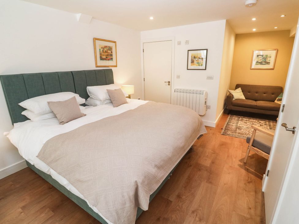 A bedroom with bed and sofa at 11 Fountain Court in Falmouth