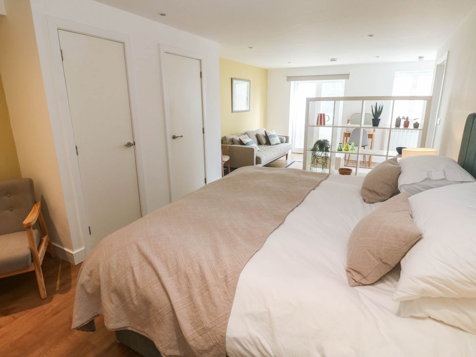 A bedroom with a bed and armchair at 11 Fountain Court in Falmouth