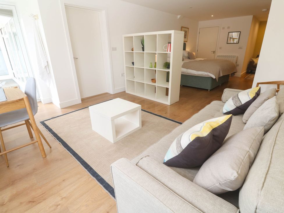 A living room with a sofa, table, and bookshelf at 11 Fountain Court in Falmouth