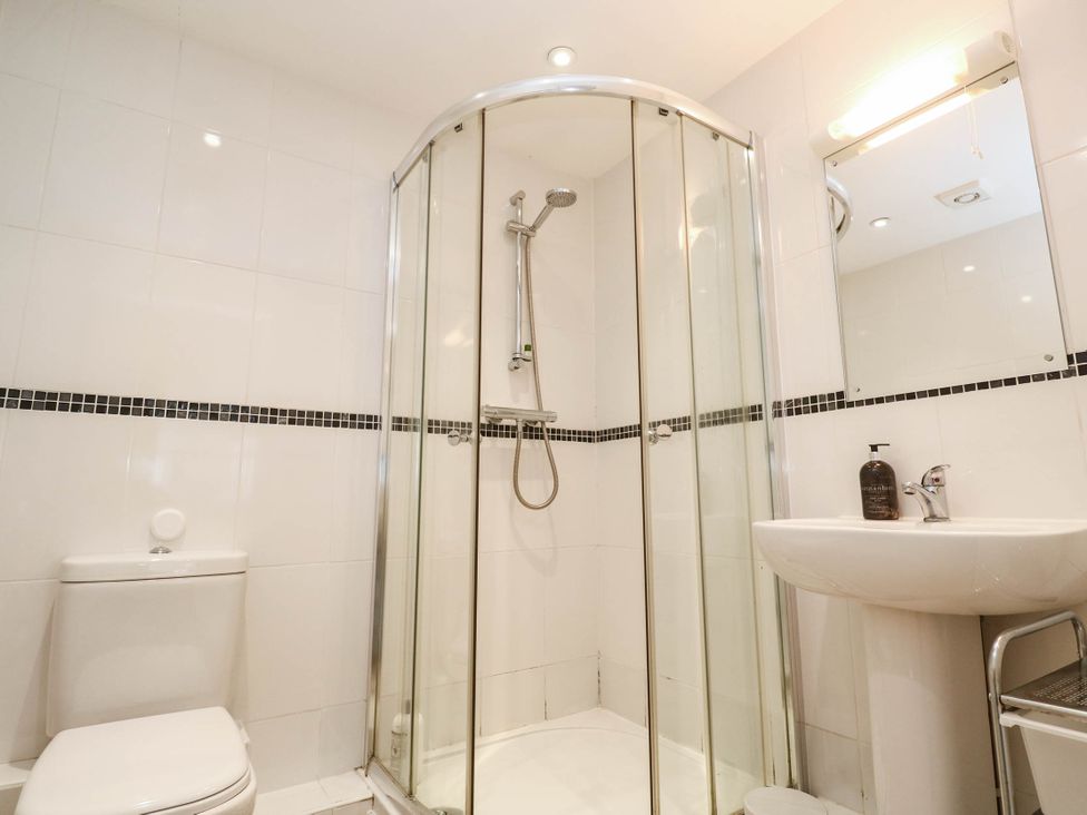 A bathroom with a shower, toilet, and sink at 11 Fountain Court in Falmouth
