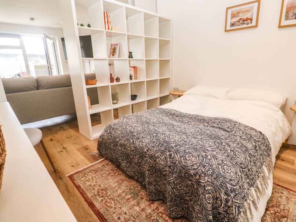 A bedroom with a bed and shelving unit at 11 Fountain Court in Falmouth