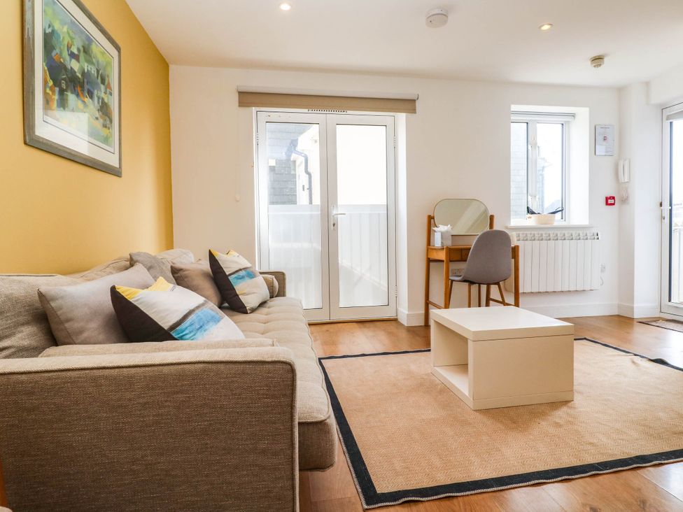A living room with a sofa and coffee table at 11 Fountain Court in Falmouth