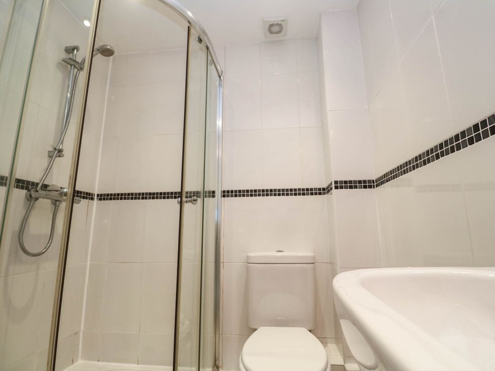 A bathroom with a shower, toilet, and sink at 11 Fountain Court in Falmouth