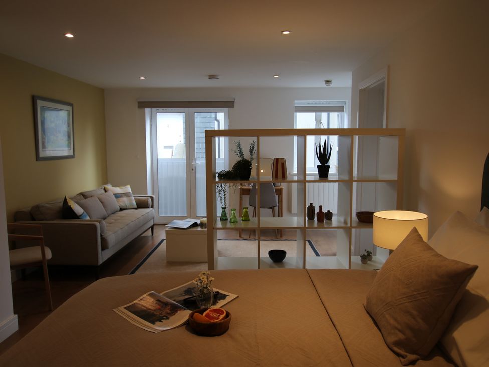 A living room with a sofa and a dining table at 11 Fountain Court in Falmouth