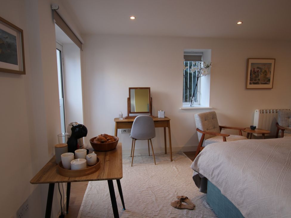 A bedroom with a bed and table set at 11 Fountain Court in Falmouth