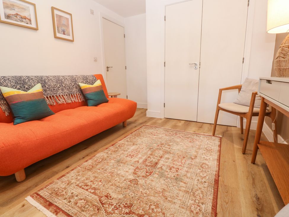 A living room with a sofa and rug at 11 Fountain Court in Falmouth