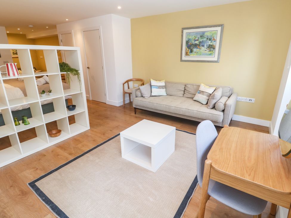 A living room with a sofa and coffee table at 11 Fountain Court in Falmouth