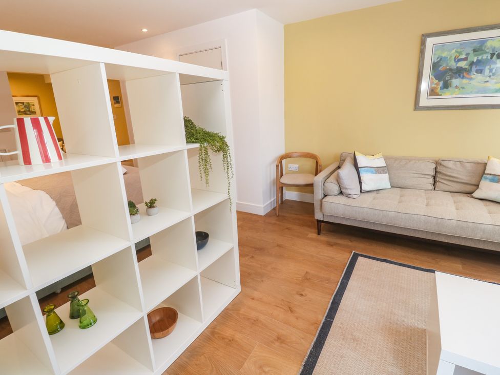 A living room with a shelf and sofa at 11 Fountain Court in Falmouth